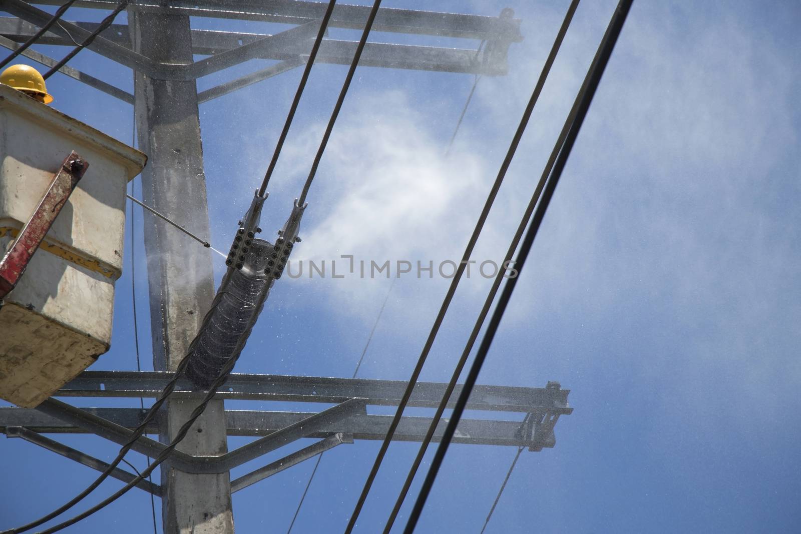 Electricity authority clean the ceramic insulator on the electric pole by high pressure washers.