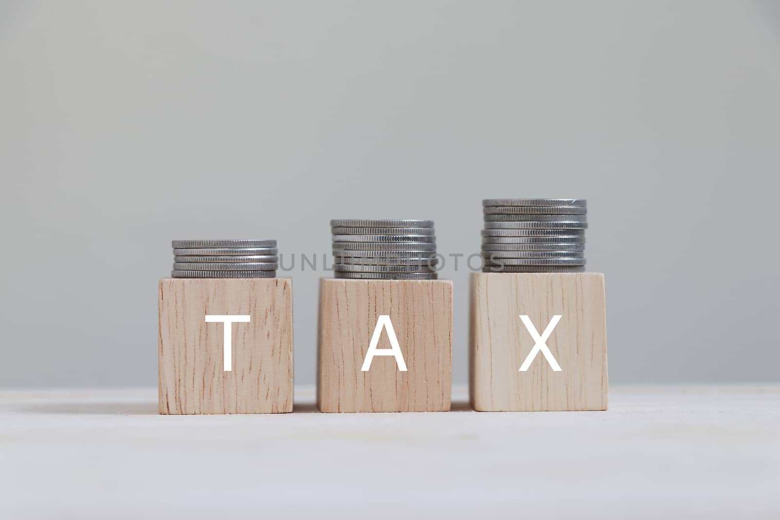 Tax with coins arranged in bar graphs on top.