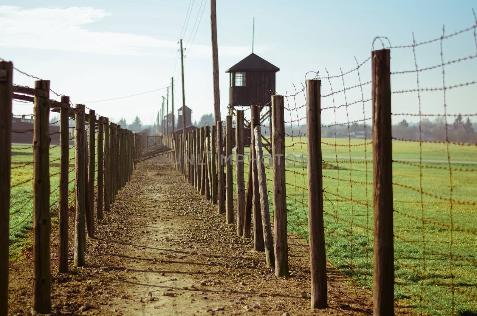 a path between barbed wire fences and a watchtower in German concentration and extermination camp Majdanek. Lublin, Poland