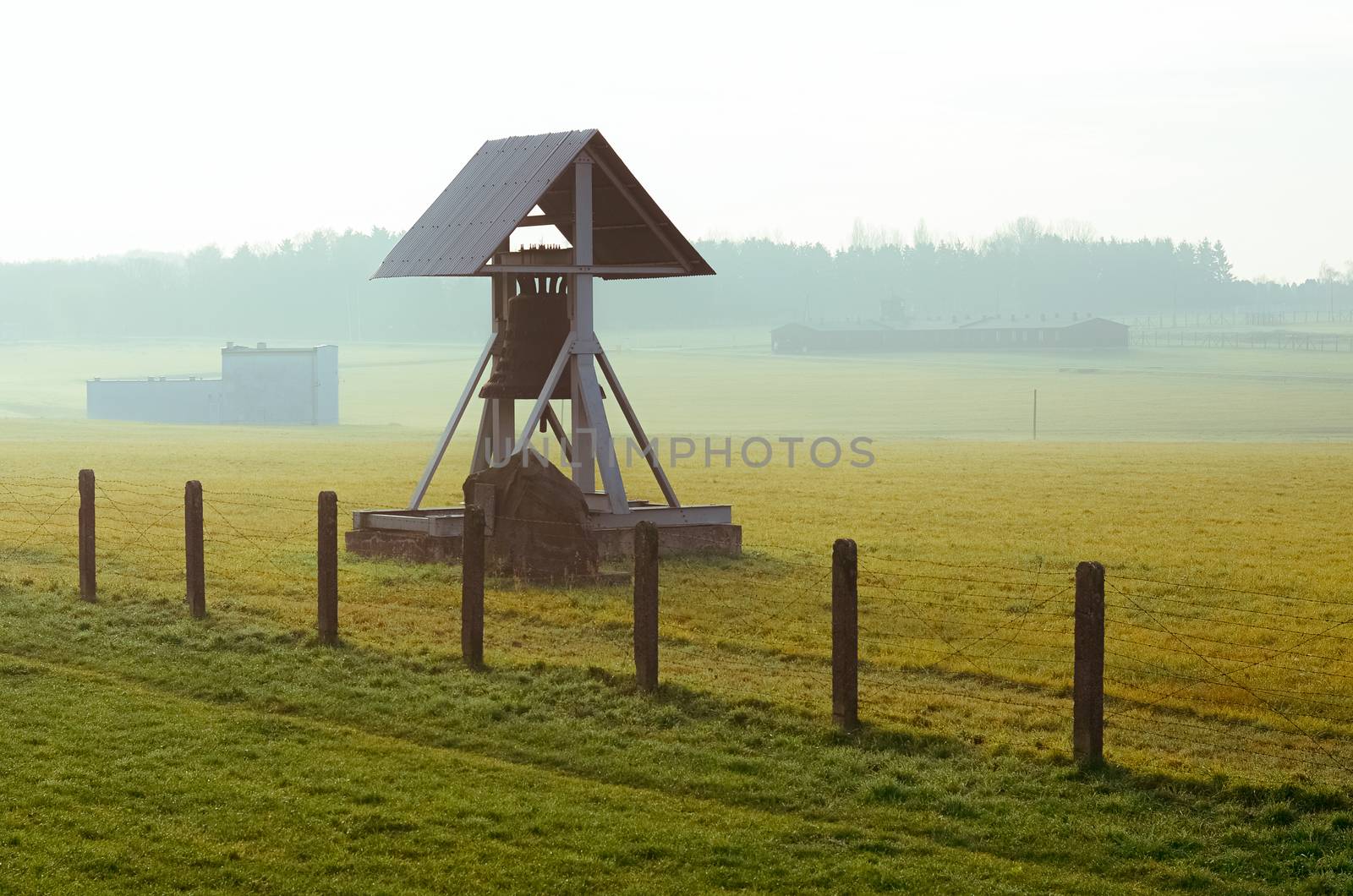 barbed wire fence and Peace bell in German concentration and extermination camp Majdanek. Lublin, Poland by chernobrovin