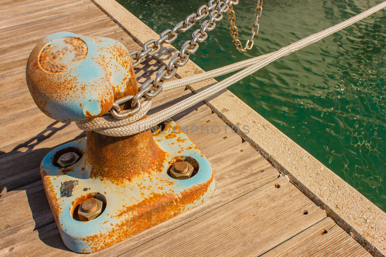 detail of a bitt with chains and ropes for mooring at the harbor by moorea