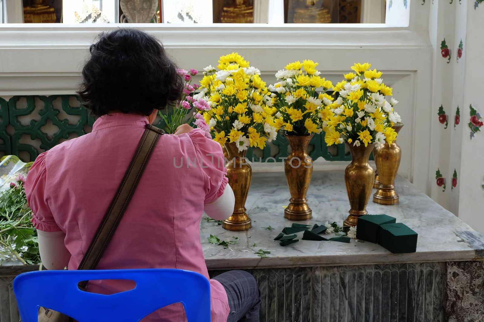 Unidentified Woman Decorating Flowers for Buddha Images. by mesamong