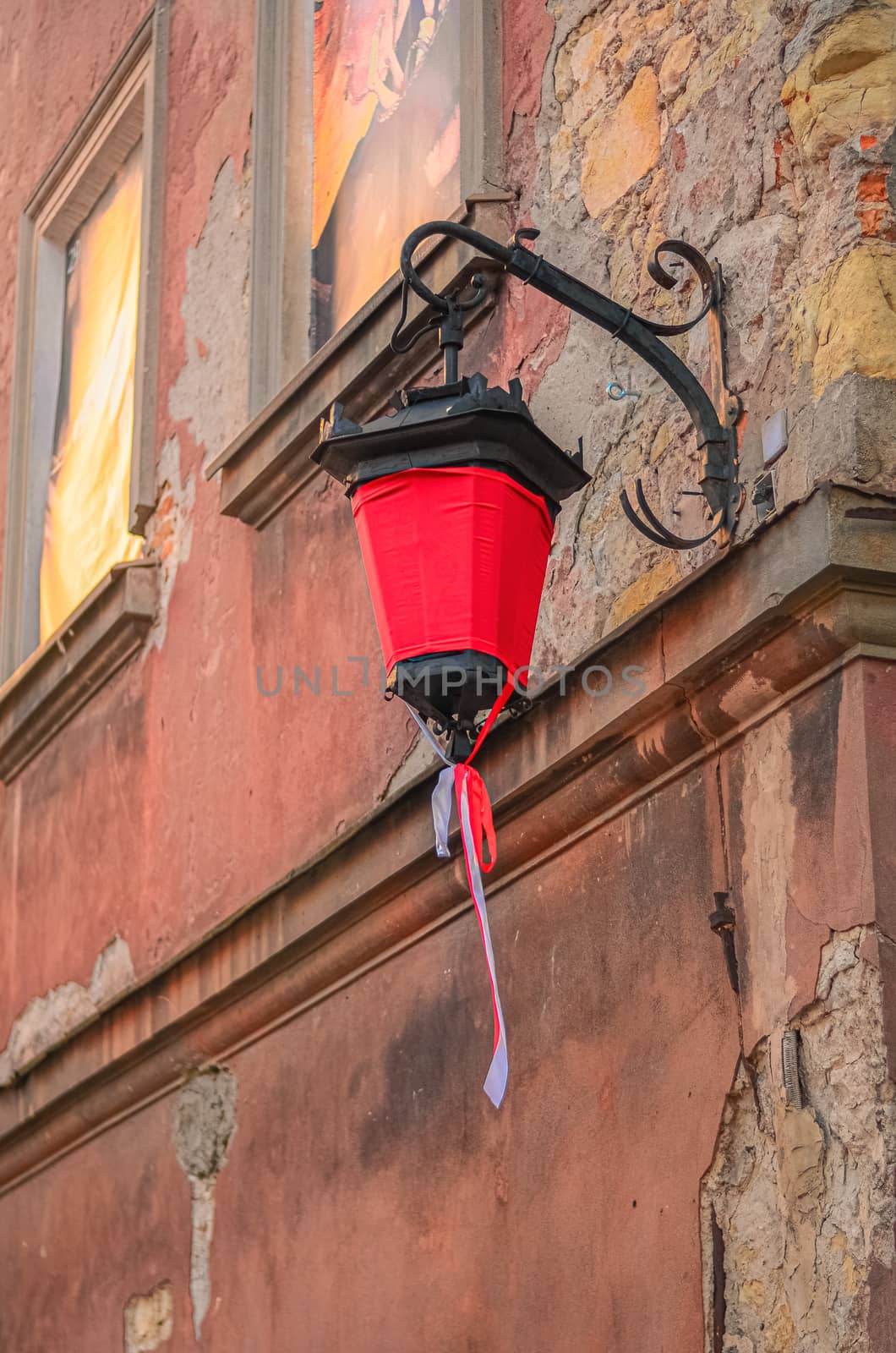 old street lamp with a red canvas on the ancient wall of a house in Lublin, Poland