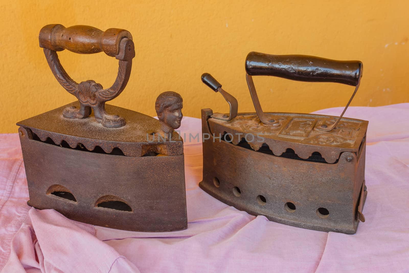 two old irons  made of cast-iron   on a shirt