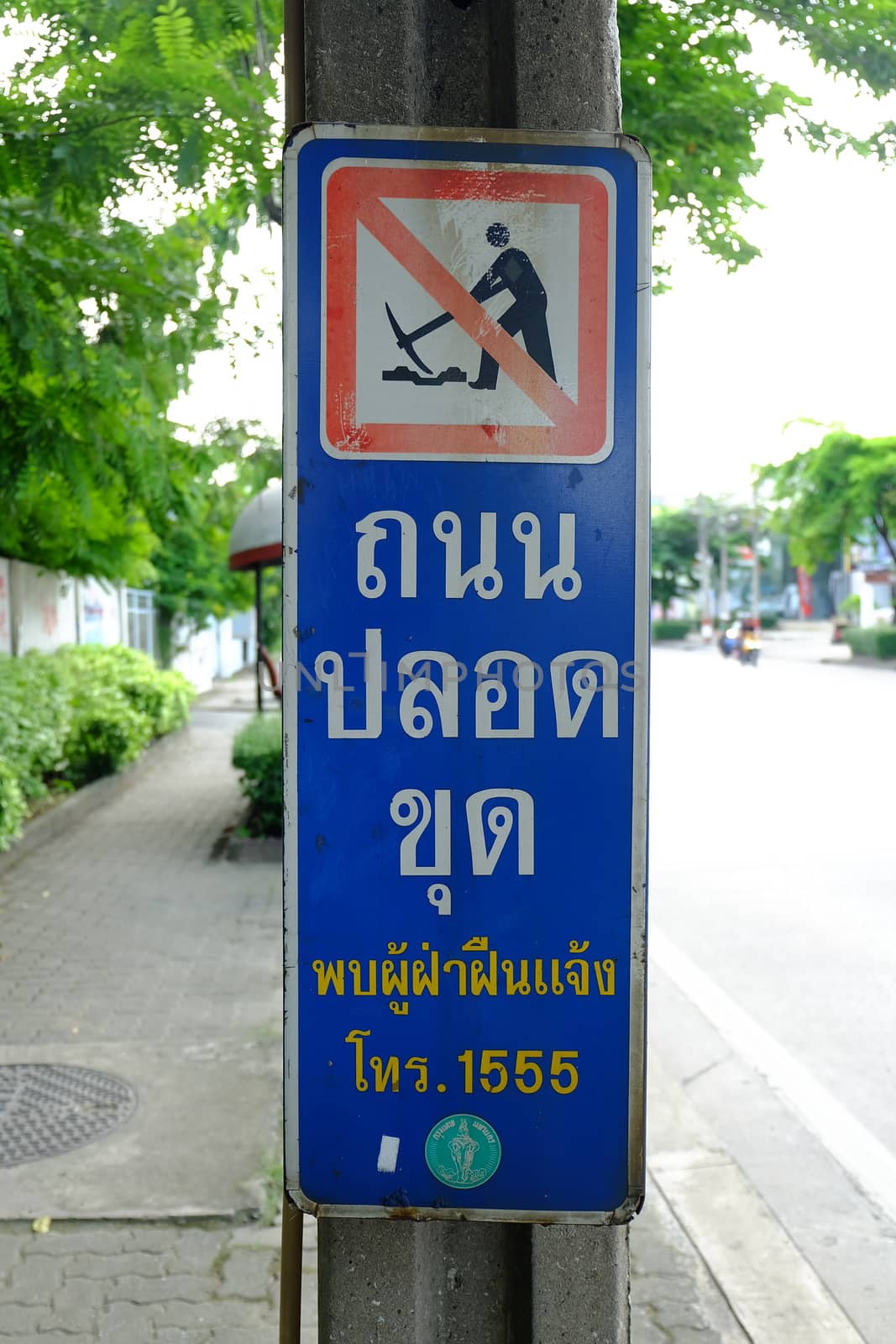 No digging sign in Bangkok, Thailand. Road digging is the main cause of traffic jams. Translation Text is "If you see someone digging, Please Call 1555".