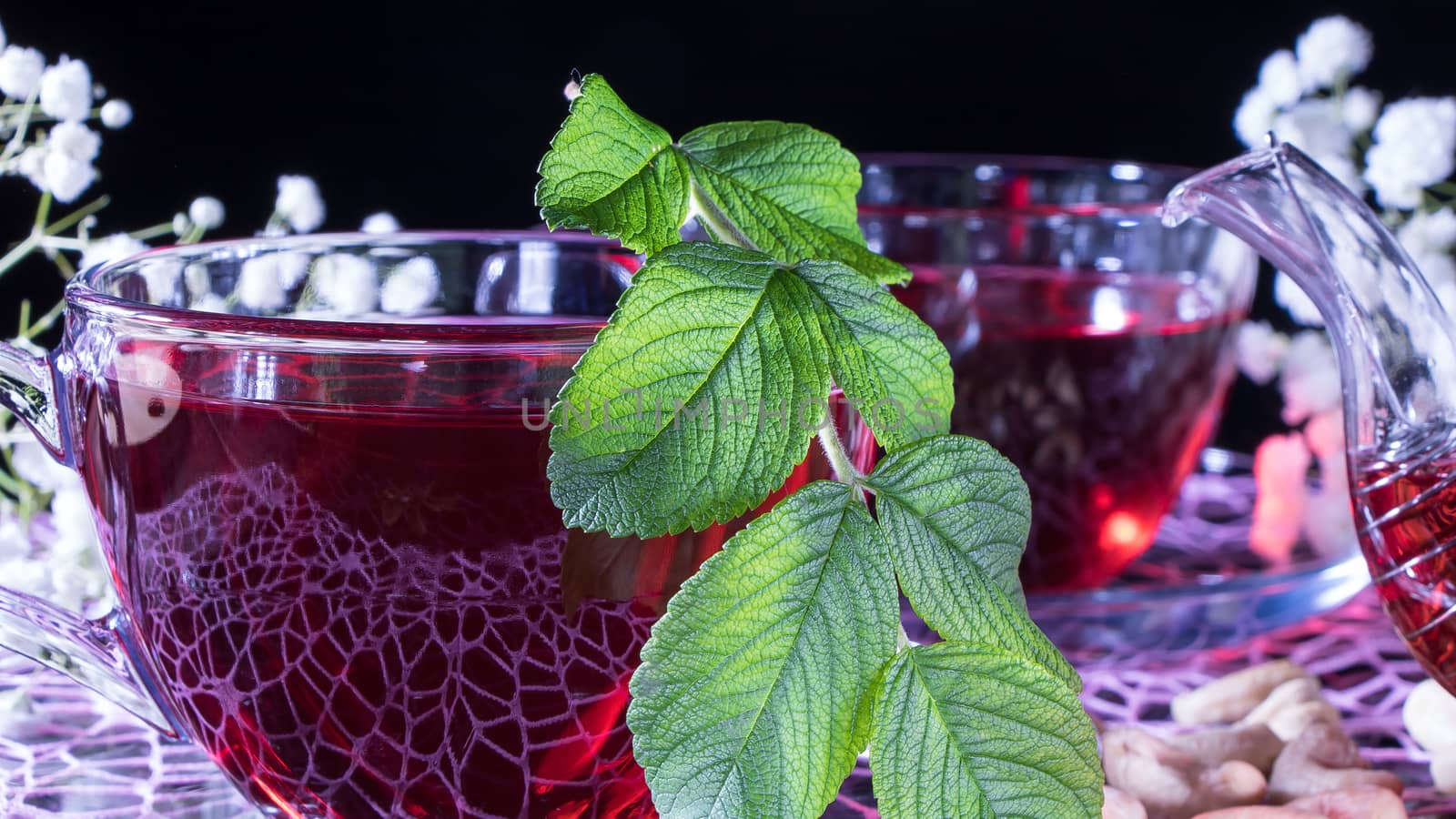 Hibiscus red tea mug with tea leaf or mint leaf close-up horizon by YevgeniySam