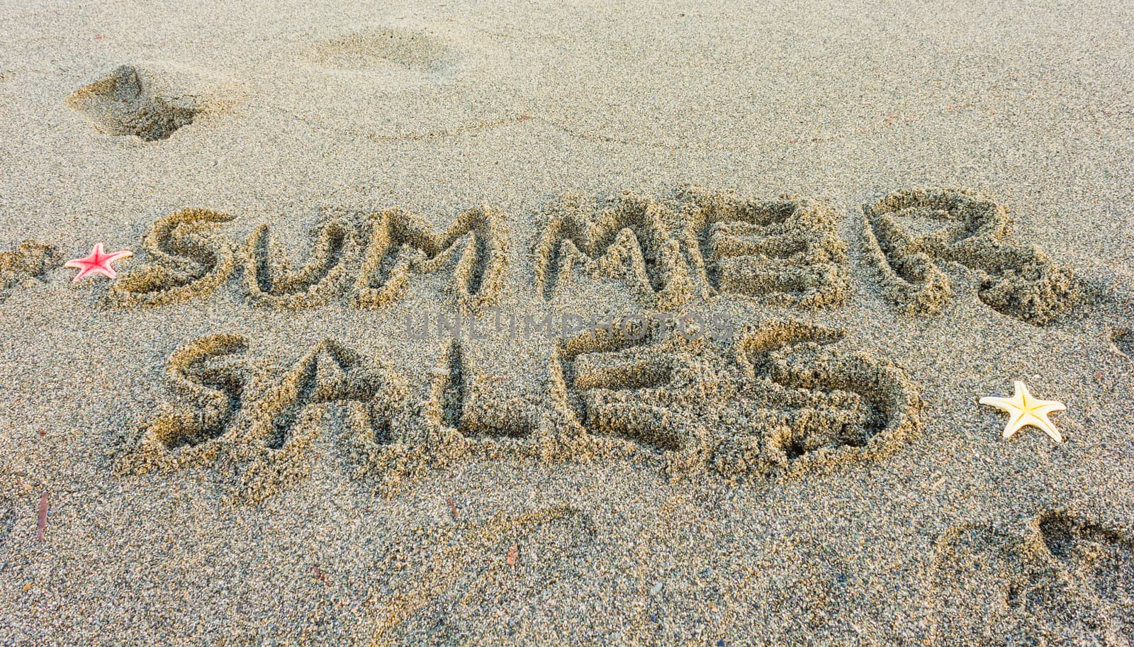 the word summer sales written on the sand