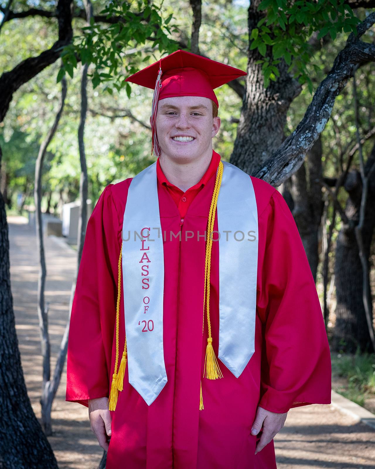 Handsome, red- headed young man posing for his High School graduation photos. Very attractive and athletic looking young boy.