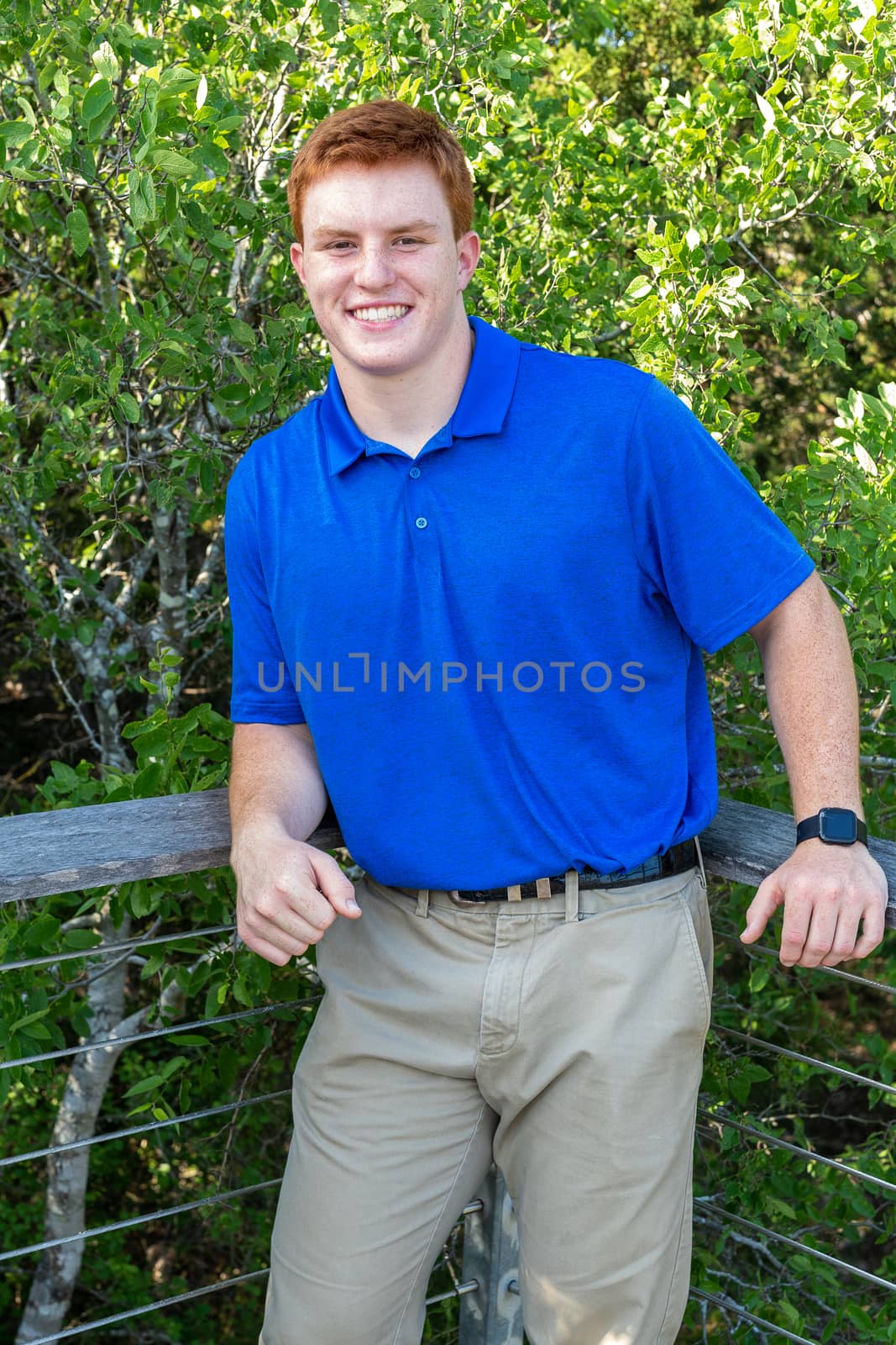 Handsome, red- headed young man posing for his High School graduation photos. Very attractive and athletic looking young boy.