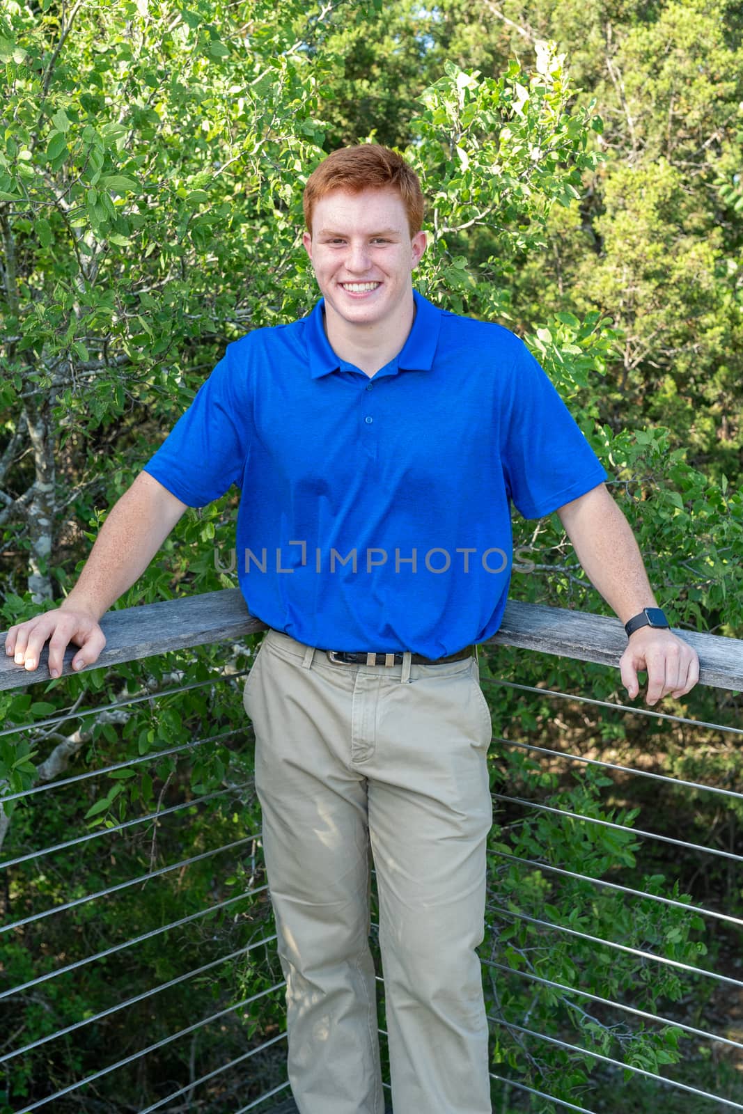 Handsome, red- headed young man posing for his High School graduation photos. Very attractive and athletic looking young boy.