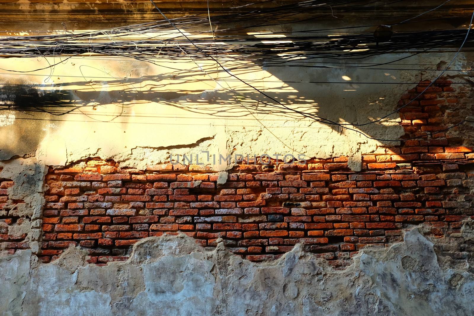 Messy Electrical Wires with Broken Old Brick Wall.