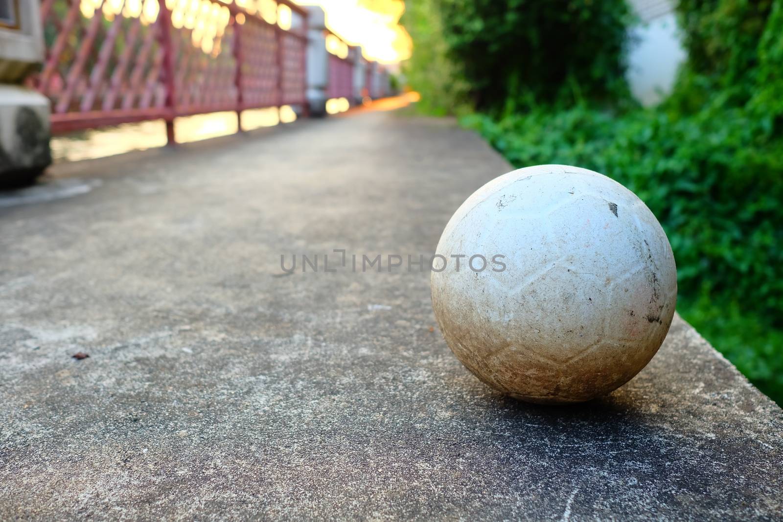 White Plastic Football on Concrete Ground. by mesamong
