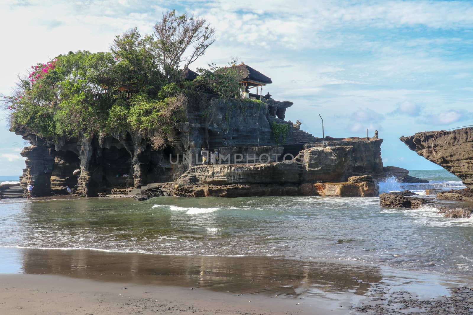 Beautiful balinese landscape. Ancient hinduism temple Tanah lot on the rock against sunset sky. Bali Island, Indonesia. famous Tanah Lot Temple on Sea in Bali Island Indonesia with blue sky and waves.