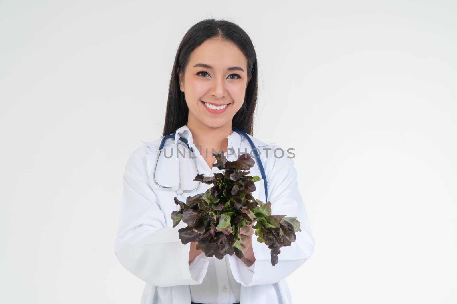 Doctor or nutritionist holding fresh vegetables and smile in the clinic. A healthy diet, the concept of nutrition food as a prescription for good health, vegetables is medicine by PattyPhoto