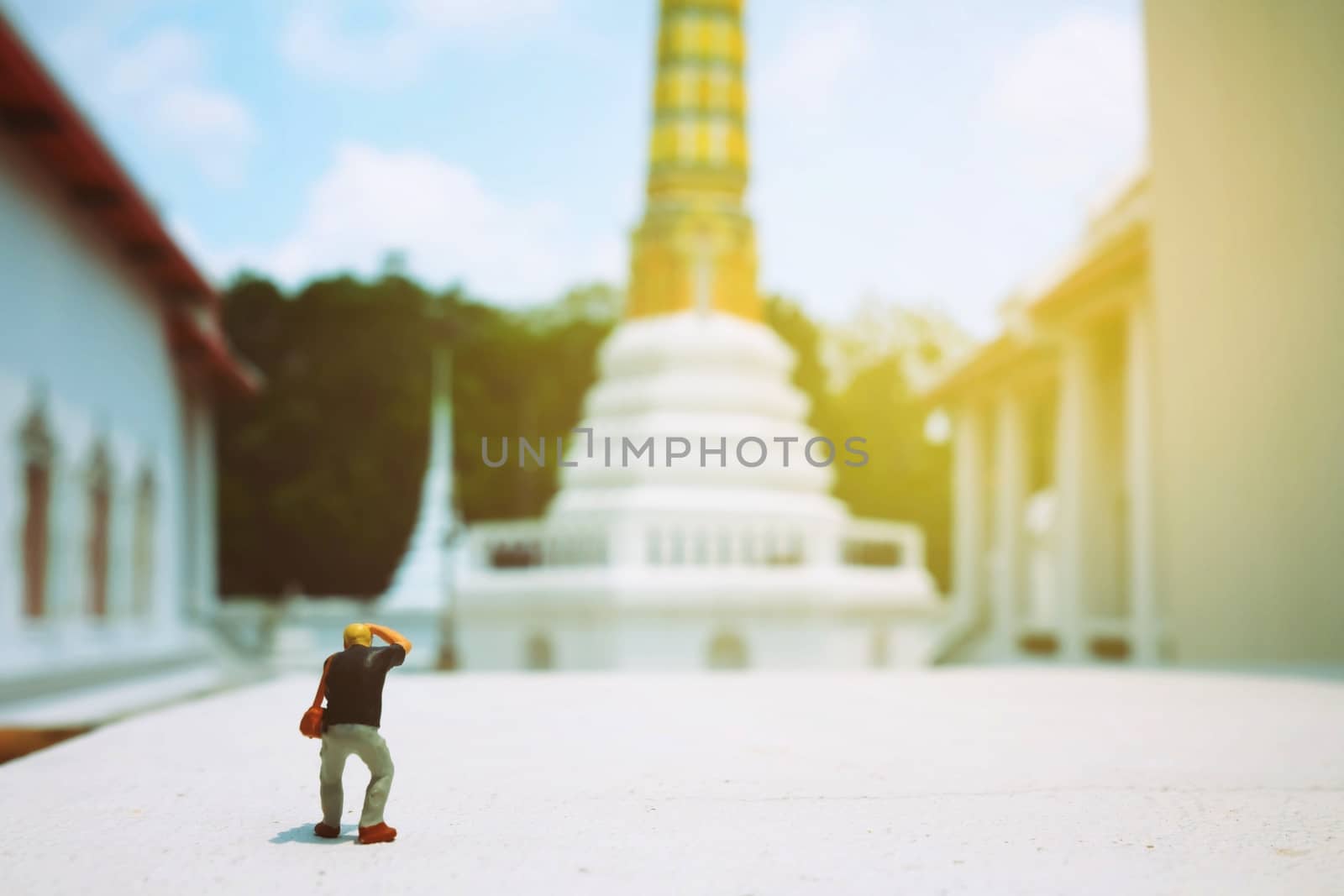 Miniature Figure Photographer Taking a Photo of  Ancient Pagoda in Thailand.