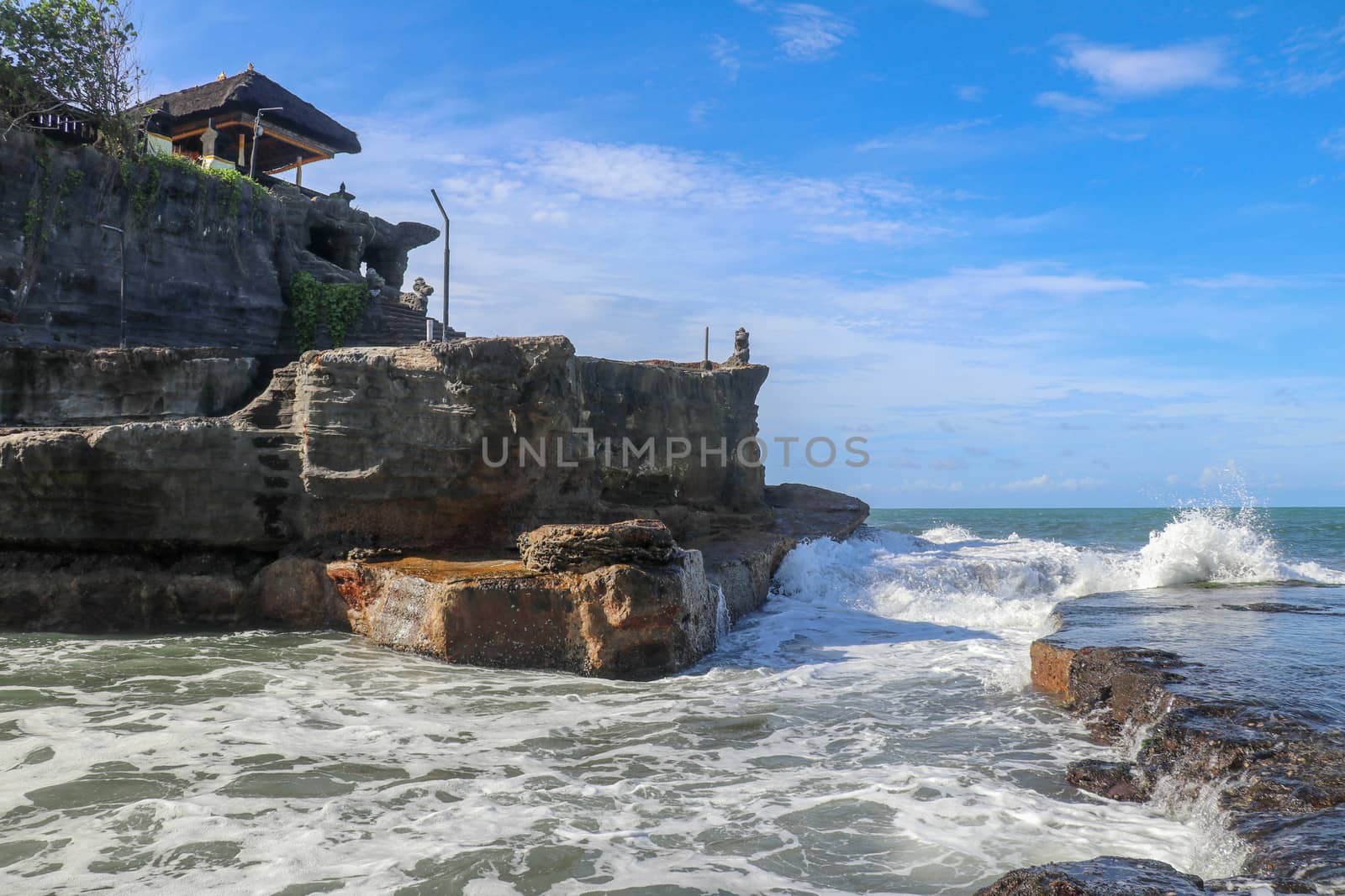 Beautiful Tanah Lot Temple in Bali Indonesia epic scene - nature and architecture background. Pilgrimage Temple of Pura Tanah Lot is perched dramatically on a large coastal rock.