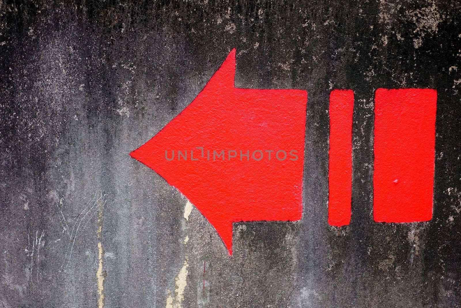 Red Arrow on Grunge Concrete Wall Background.