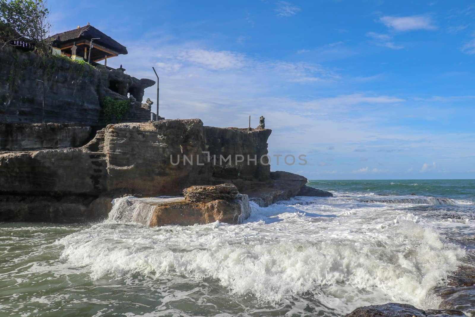 Beautiful Tanah Lot Temple in Bali Indonesia epic scene - nature and architecture background. Pilgrimage Temple of Pura Tanah Lot is perched dramatically on a large coastal rock.