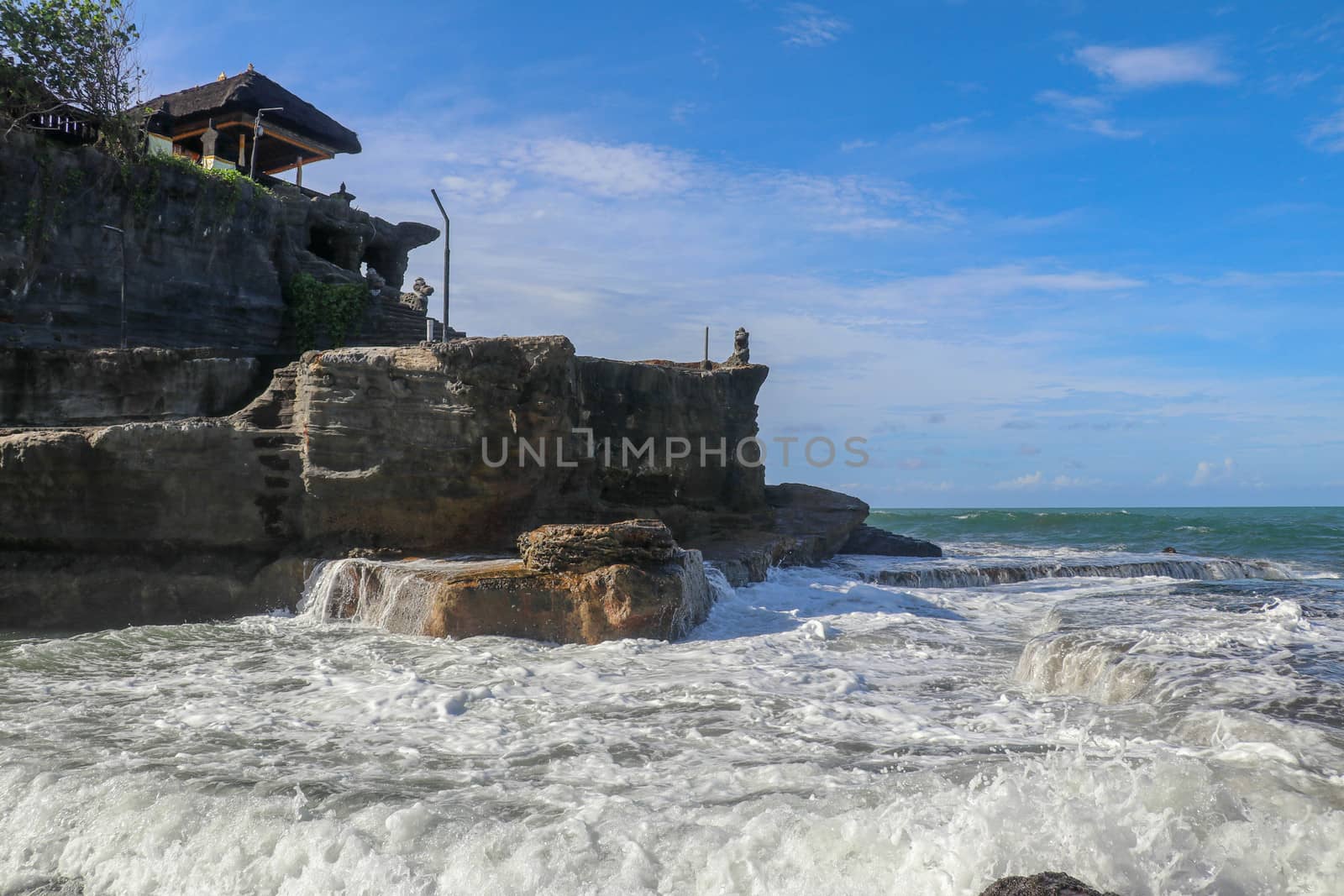 Beautiful Tanah Lot Temple in Bali Indonesia epic scene - nature and architecture background. Pilgrimage Temple of Pura Tanah Lot is perched dramatically on a large coastal rock.