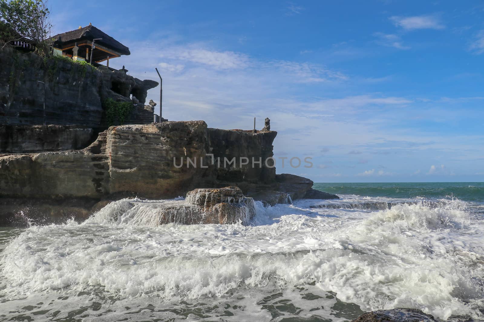 Beautiful Tanah Lot Temple in Bali Indonesia epic scene - nature and architecture background. Pilgrimage Temple of Pura Tanah Lot is perched dramatically on a large coastal rock.