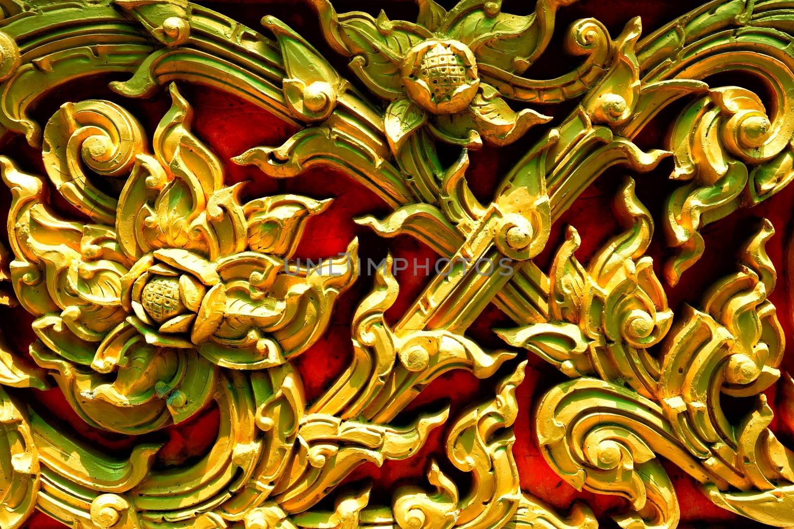 Closed-up Vintage Golden Thai Sculpture on Stone Wall.