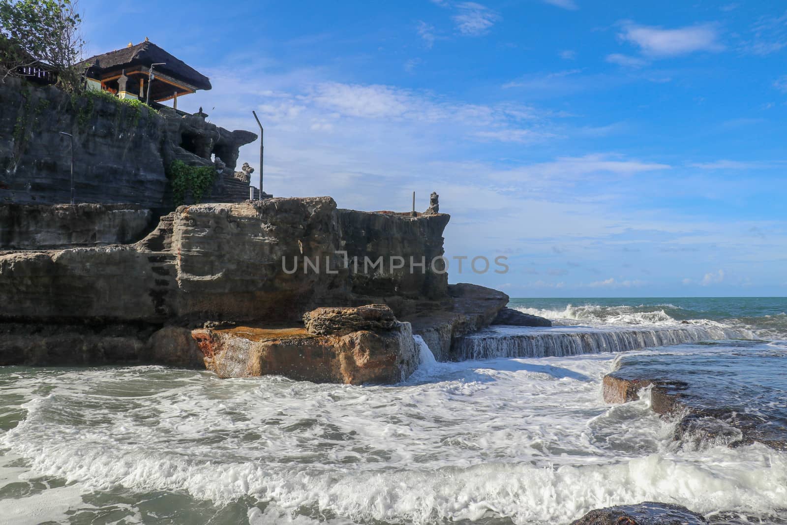 Beautiful Tanah Lot Temple in Bali Indonesia epic scene - nature and architecture background. Pilgrimage Temple of Pura Tanah Lot is perched dramatically on a large coastal rock.