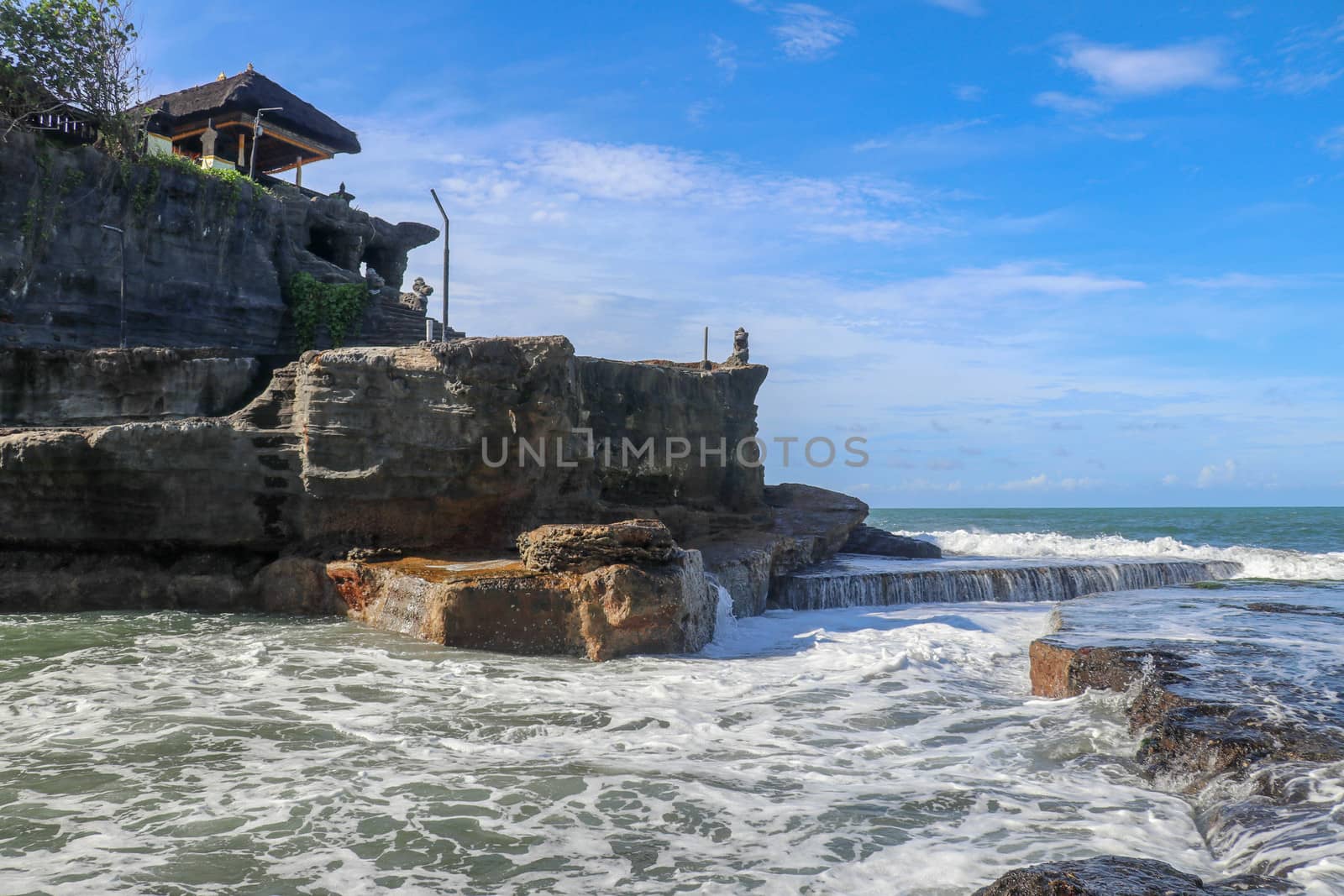 Beautiful Tanah Lot Temple in Bali Indonesia epic scene - nature and architecture background. Pilgrimage Temple of Pura Tanah Lot is perched dramatically on a large coastal rock.