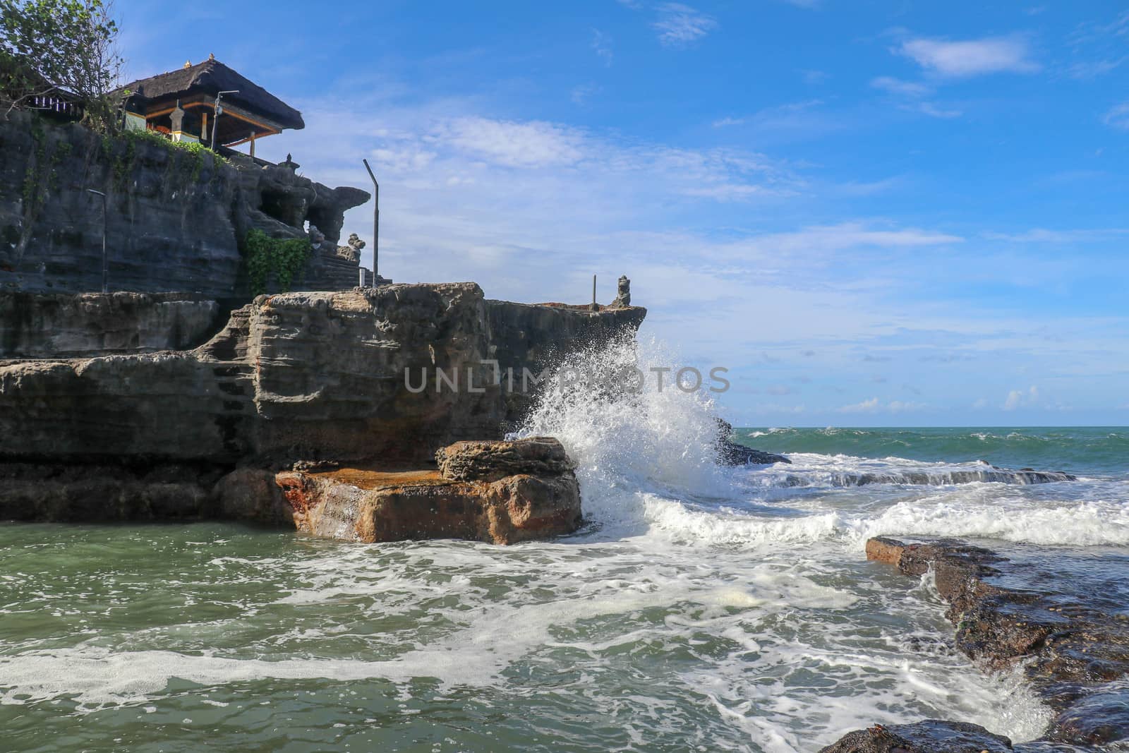 Beautiful Tanah Lot Temple in Bali Indonesia epic scene - nature and architecture background. Pilgrimage Temple of Pura Tanah Lot is perched dramatically on a large coastal rock.