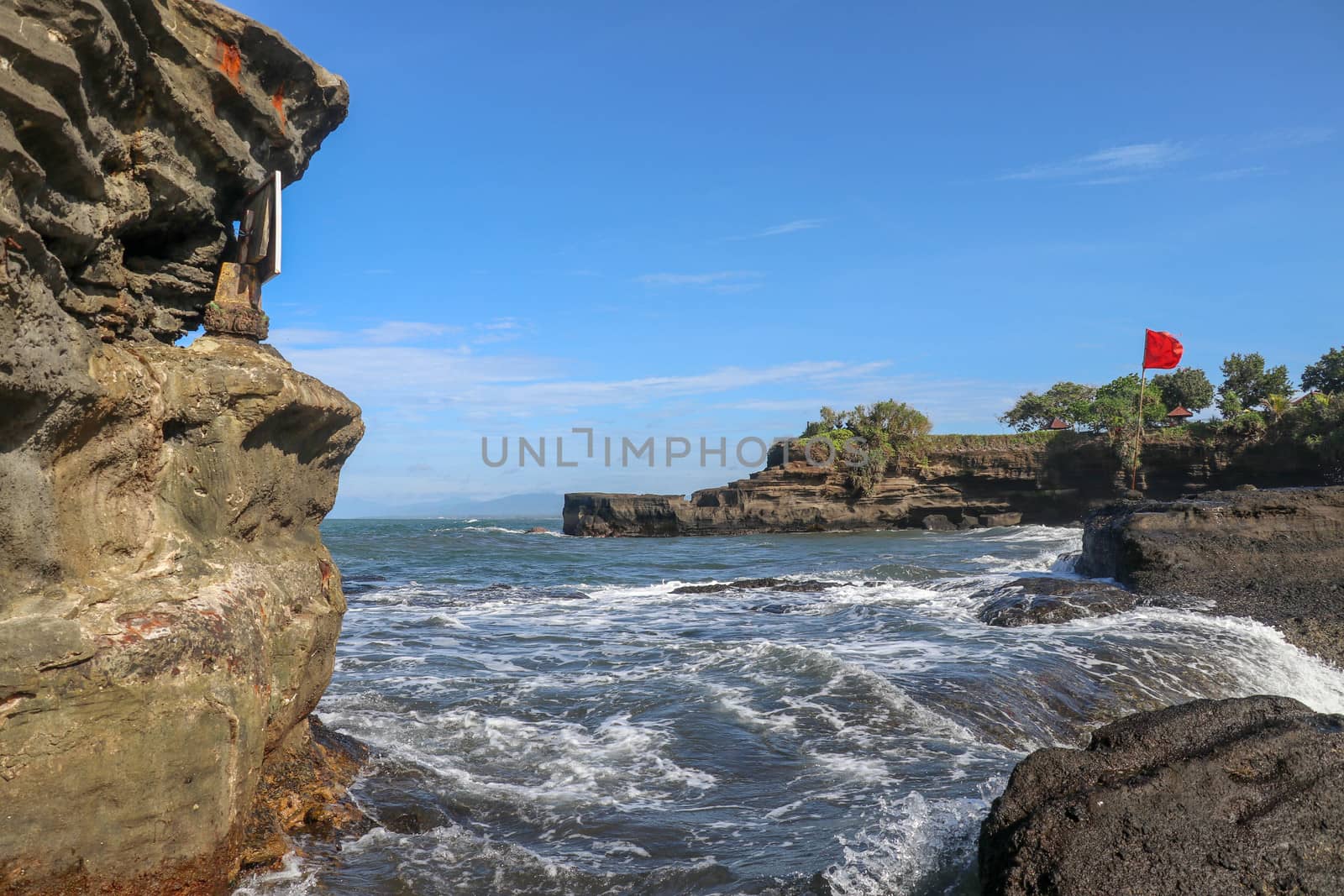Temple on the Indian Ocean coast near the Sacred Balinese temple Tanah Lot. Pura Batu Bolong on the edge of a cliff at coastline with hole in the rock. Holy place for local indonesian people