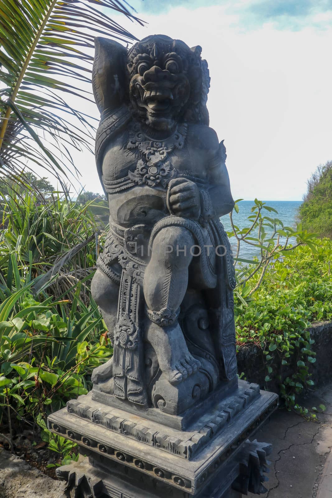 Closeup of stone statue in Temple Batu Bolong near to Tanah Lot in Bali, Indonesia. A carved statue with fine details that stands outside the entrance to Hindu temple as a guardian. Balinese culture.