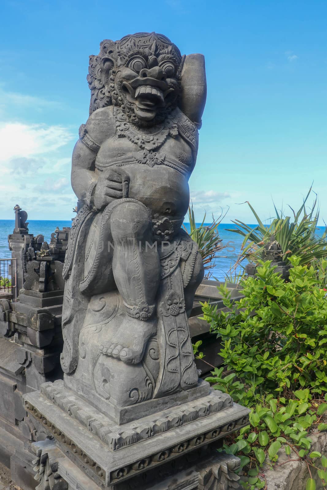 Closeup of stone statue in Temple Batu Bolong near to Tanah Lot in Bali, Indonesia. A carved statue with fine details that stands outside the entrance to Hindu temple as a guardian. Balinese culture.