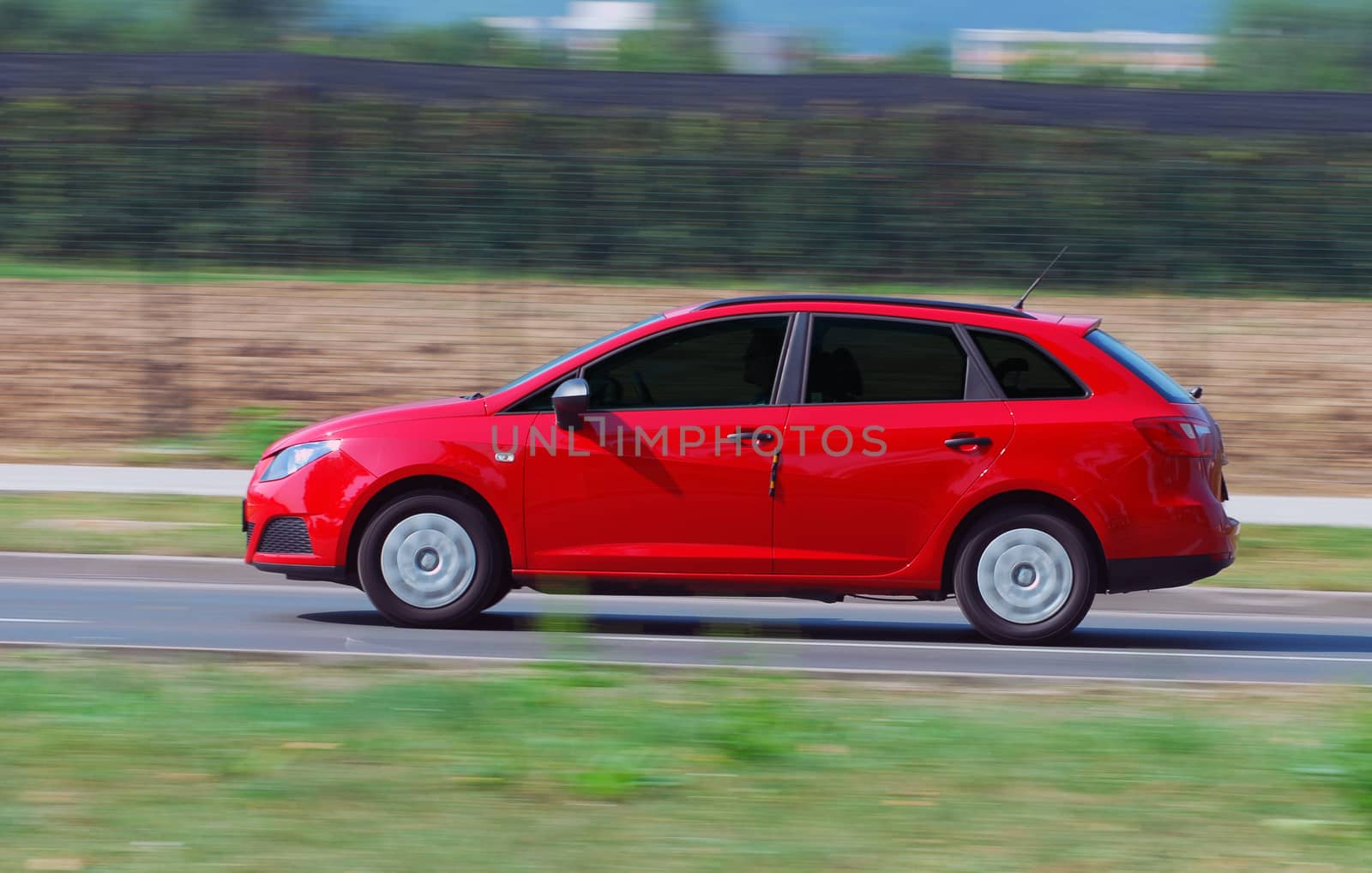 red station wagon photographed in motion by aselsa