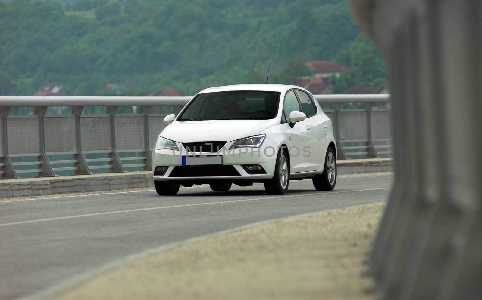 white car in motion photographed on the bridge