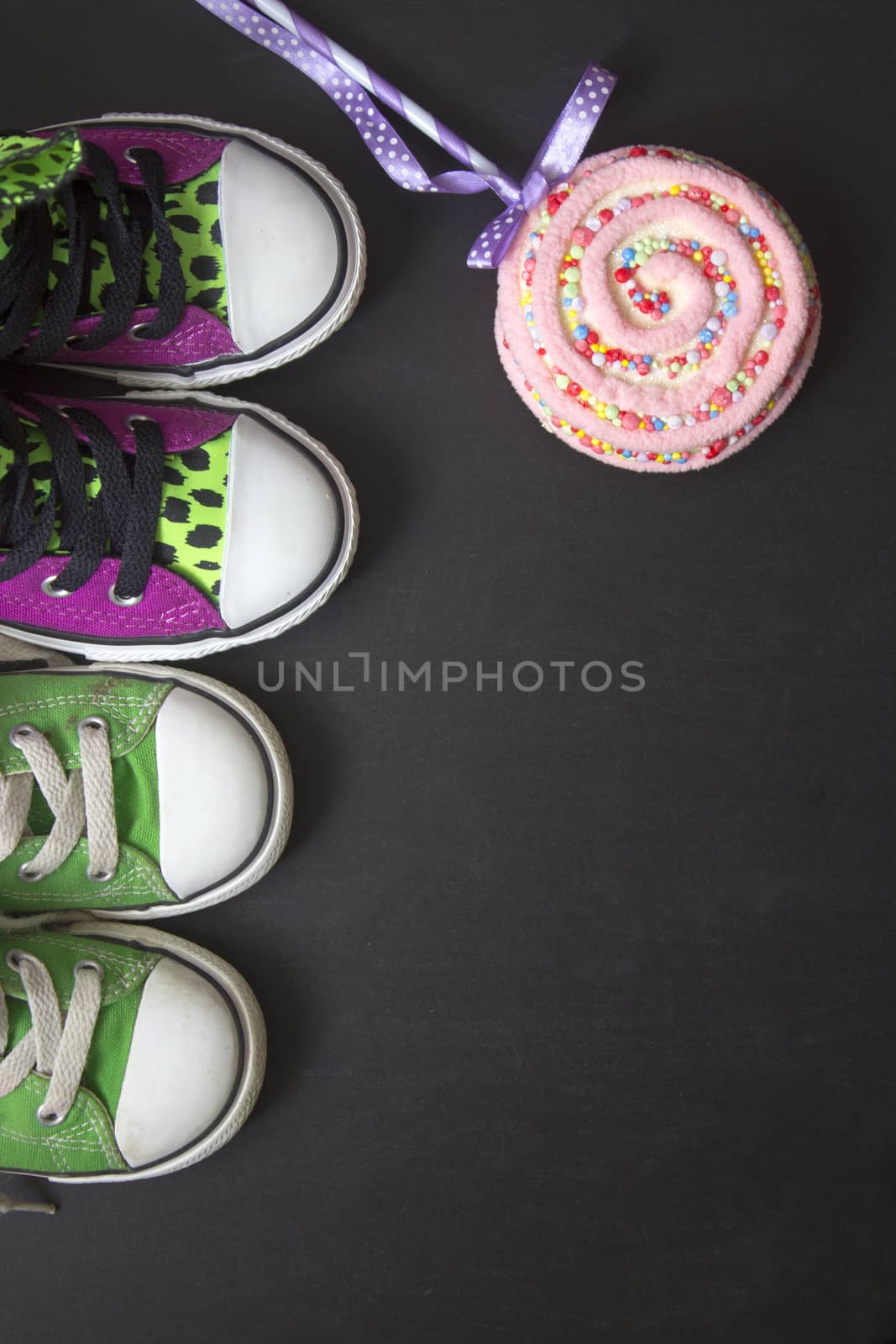 Top view of two pairs of sneakers on black board, with copy space