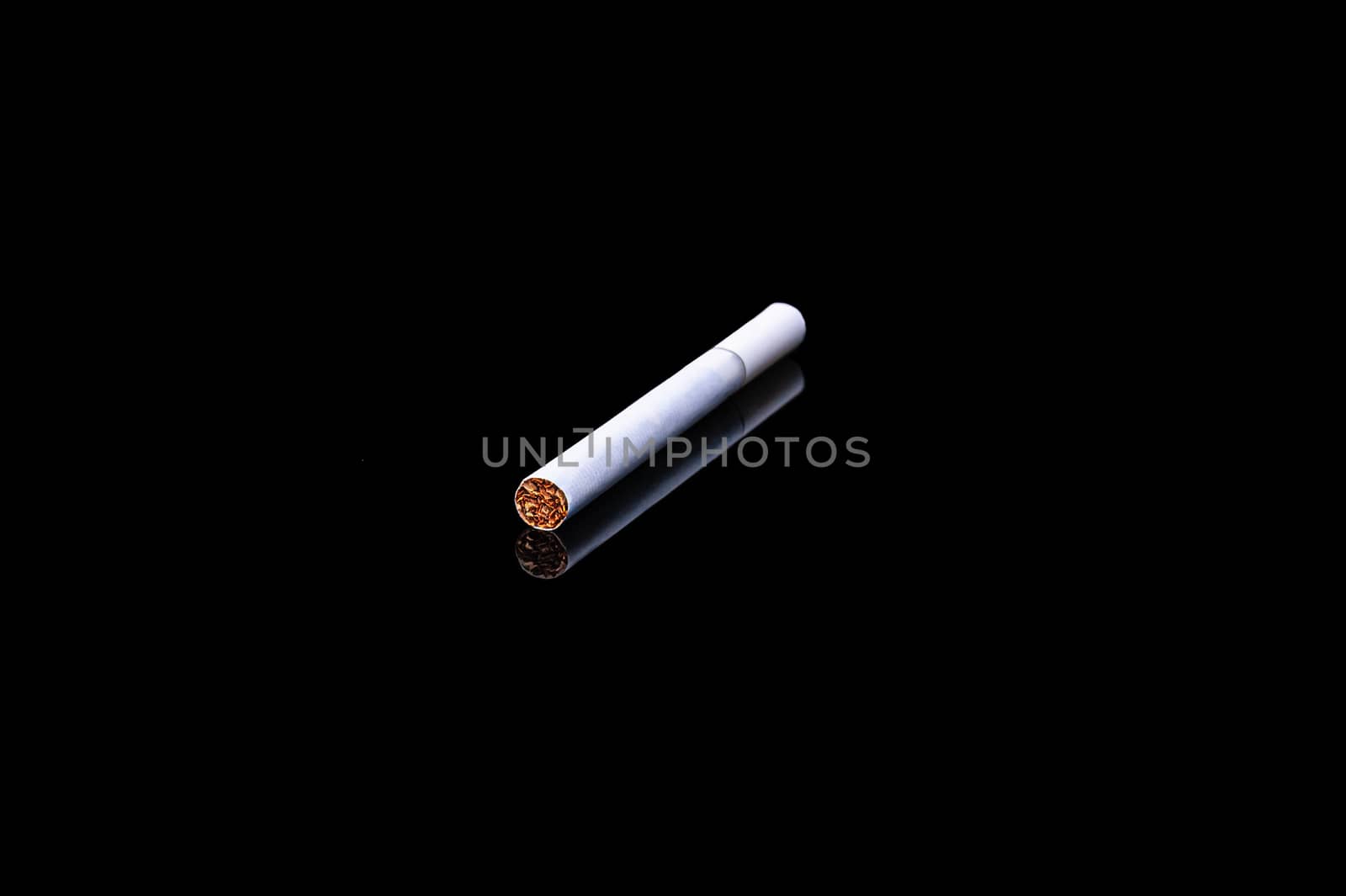 white filter cigarette on isolated black background with reflection by chernobrovin