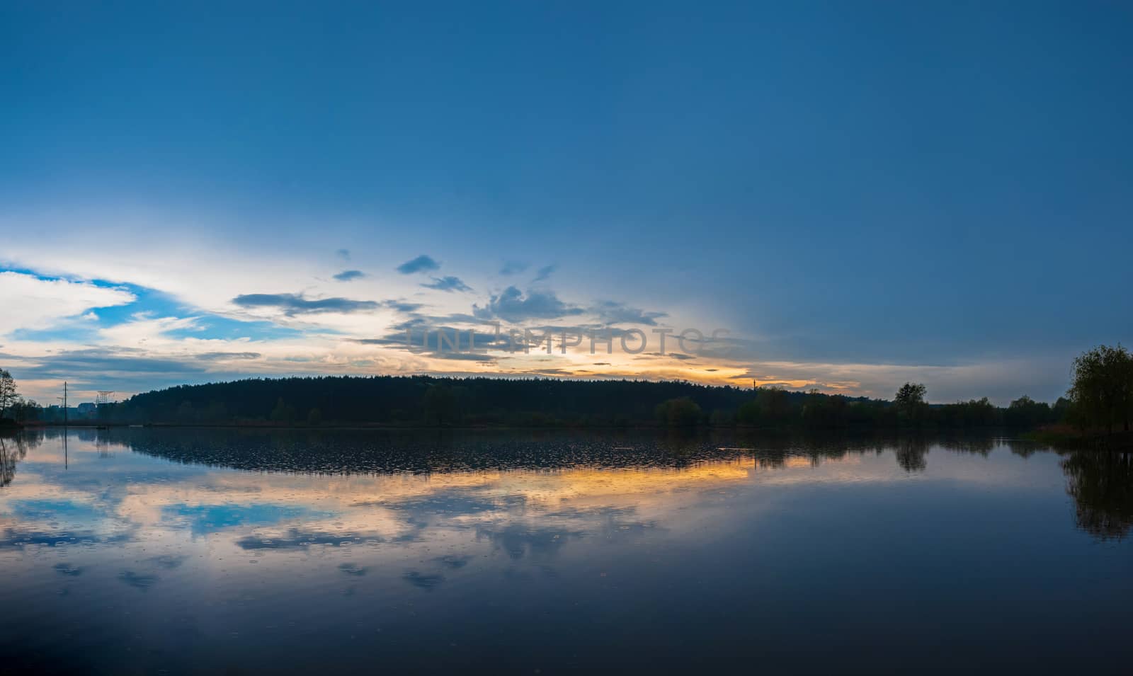 panoramic landscape view of a big blue river at sunset near the forest. Pond 14, known as the fifth glade. Kyiv, Ukraine by chernobrovin