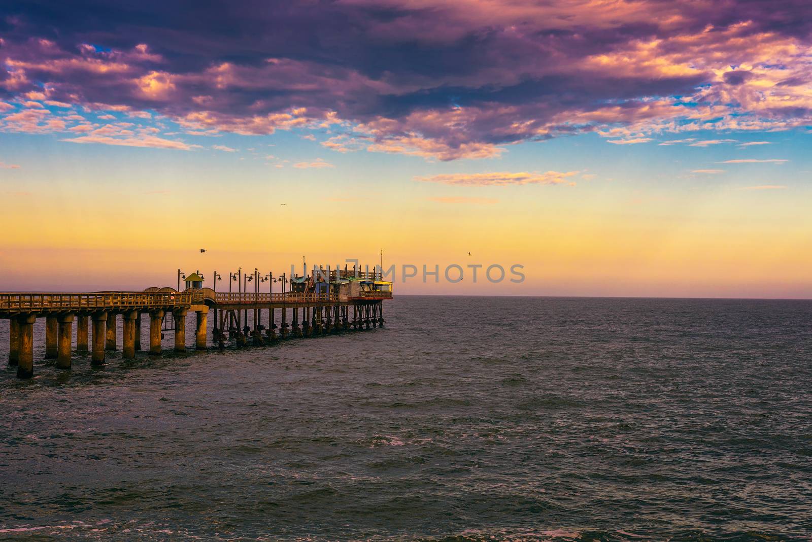 Sunset over the old historic jetty in Swakopmund, Namibia by nickfox