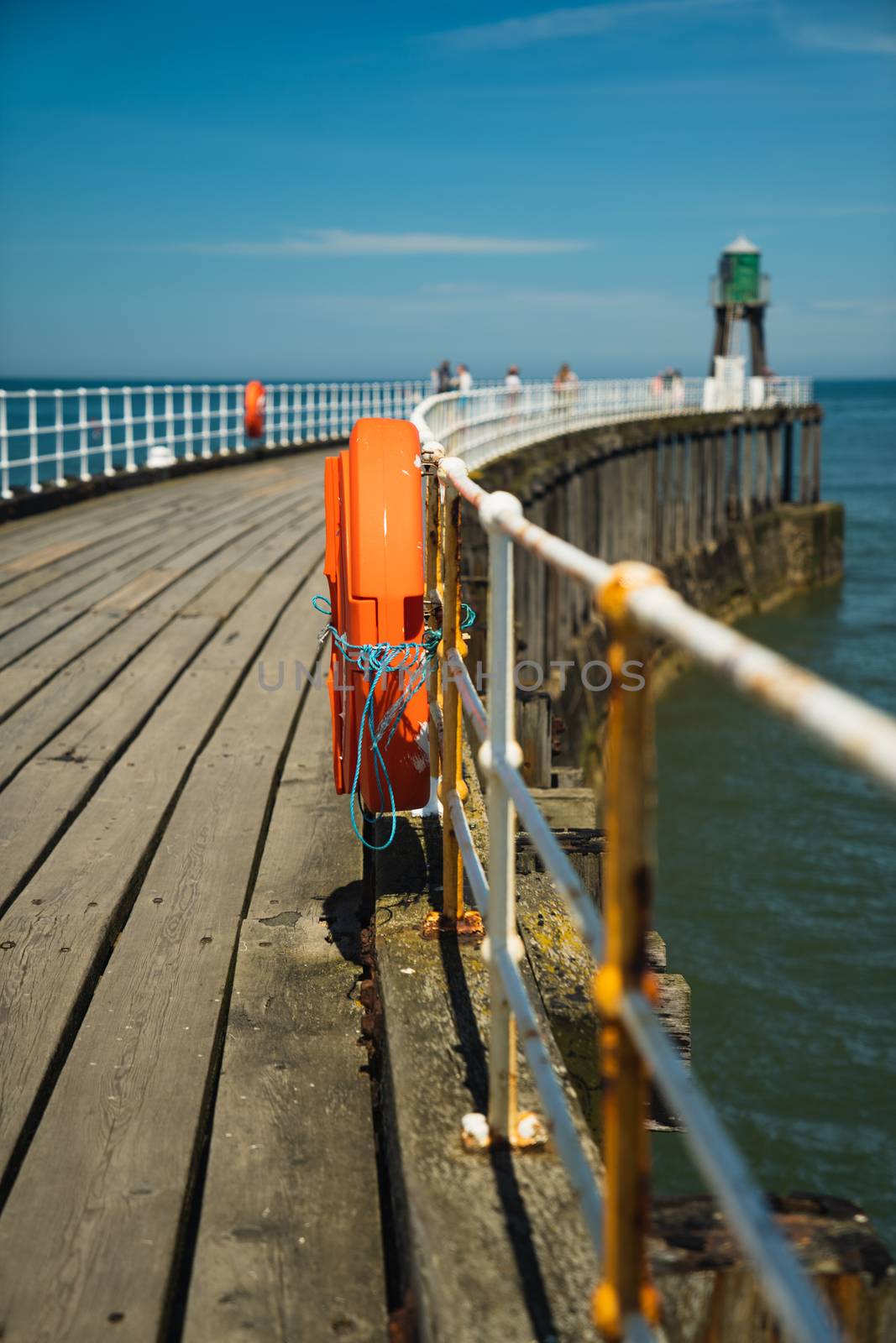 The pier in Whitby in North Yorkshire, England with an orange lifebuoy ring in the foreground