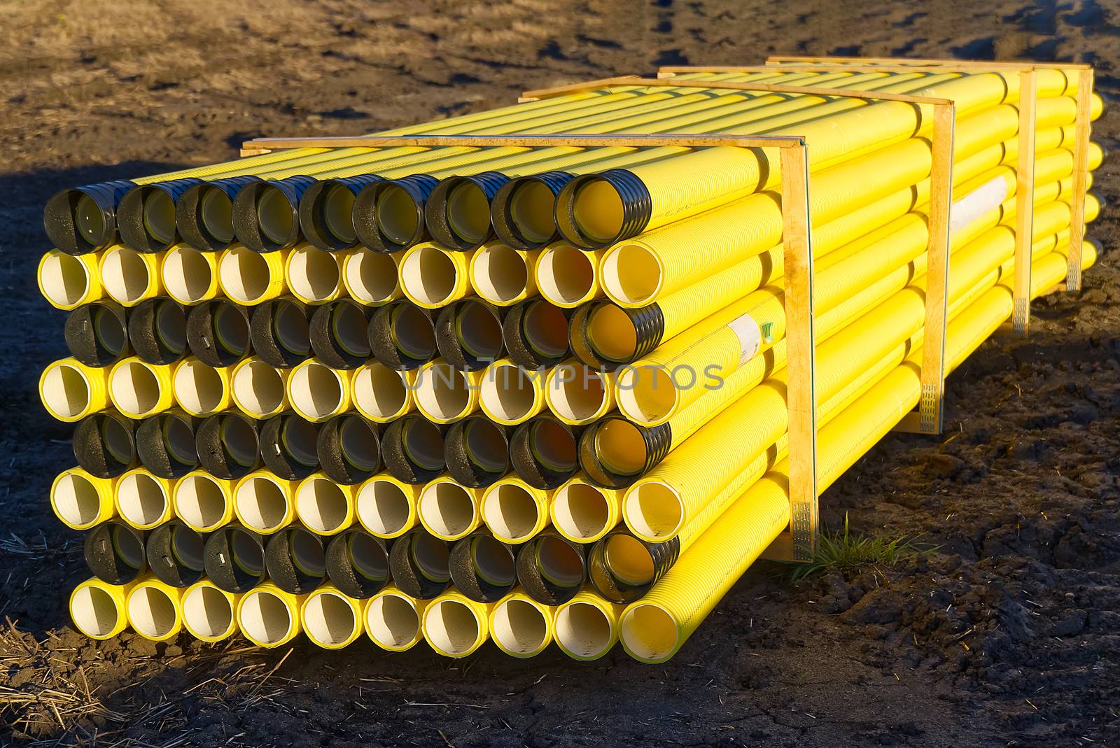 yellow plastic pipes for laying electricity cables underground. by PhotoTime