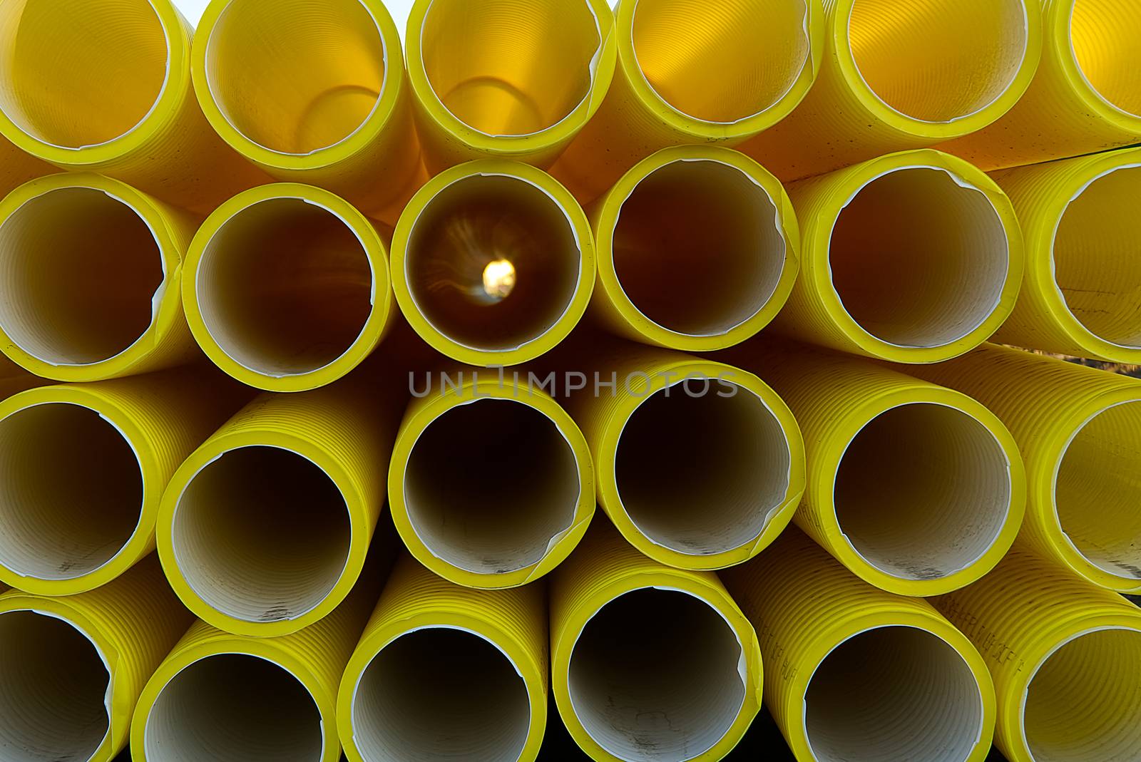 yellow plastic pipes for laying electricity cables underground. texture or abstract background. by PhotoTime