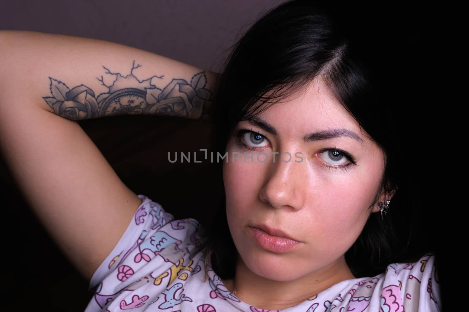 close up portrait of lovely brunette girl with makeup and tattoo on her arm by chernobrovin