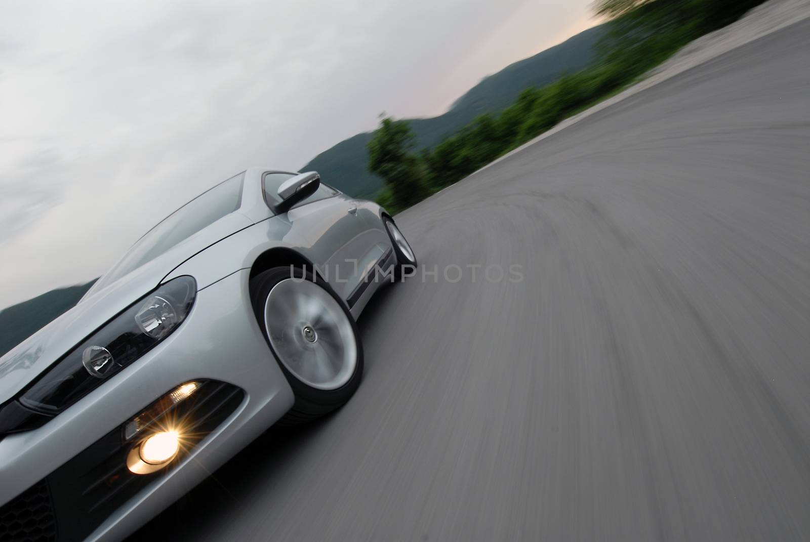 a fragment of a car driving fast on a mountain road