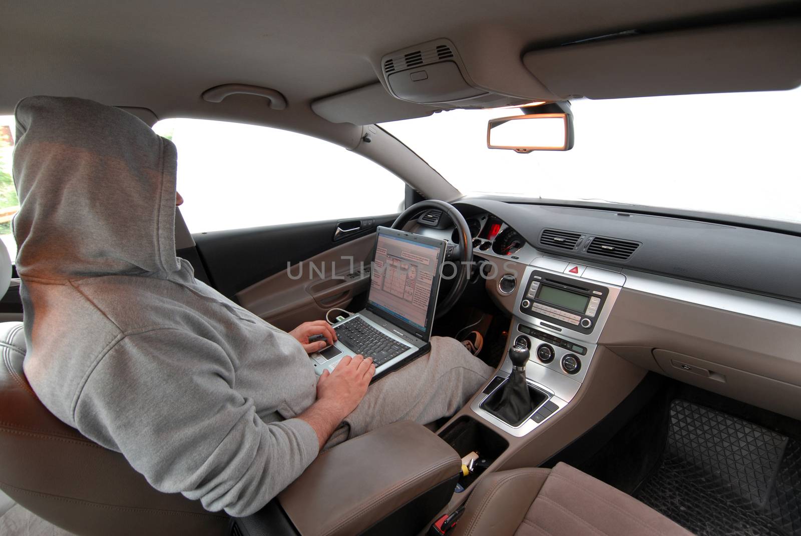 Man stealing data from a laptop sitting in a car