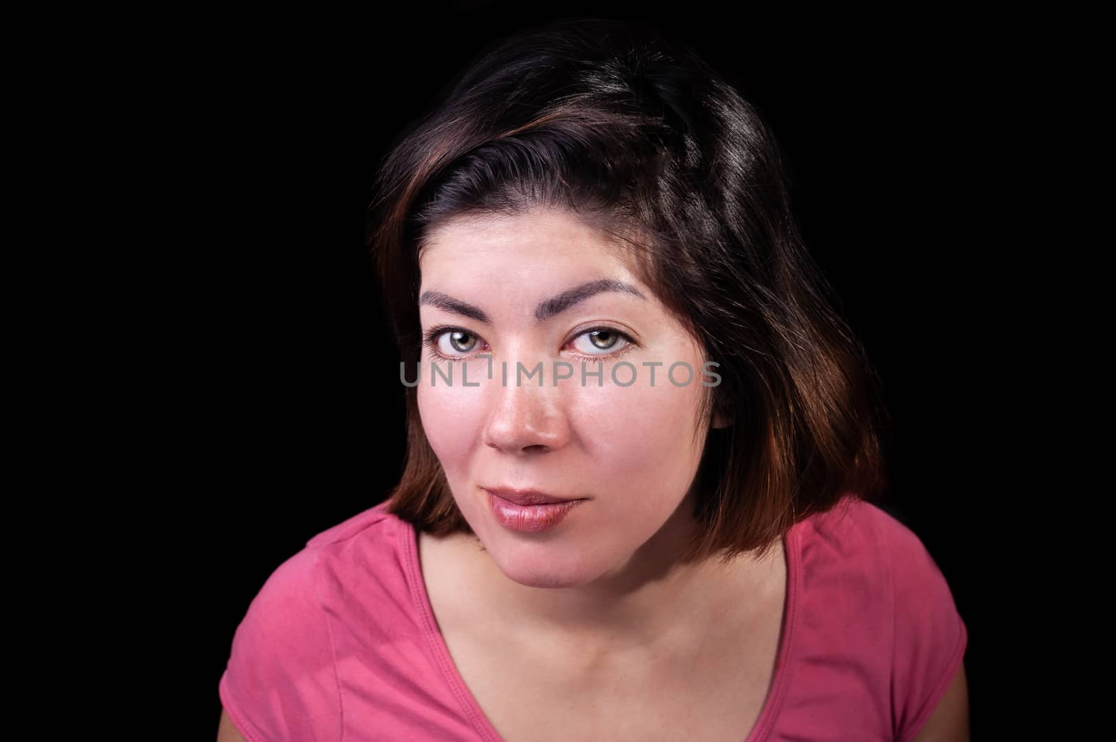 portrait of a beautiful brunette girl with makeup in a pink t-shirt on an isolated black background