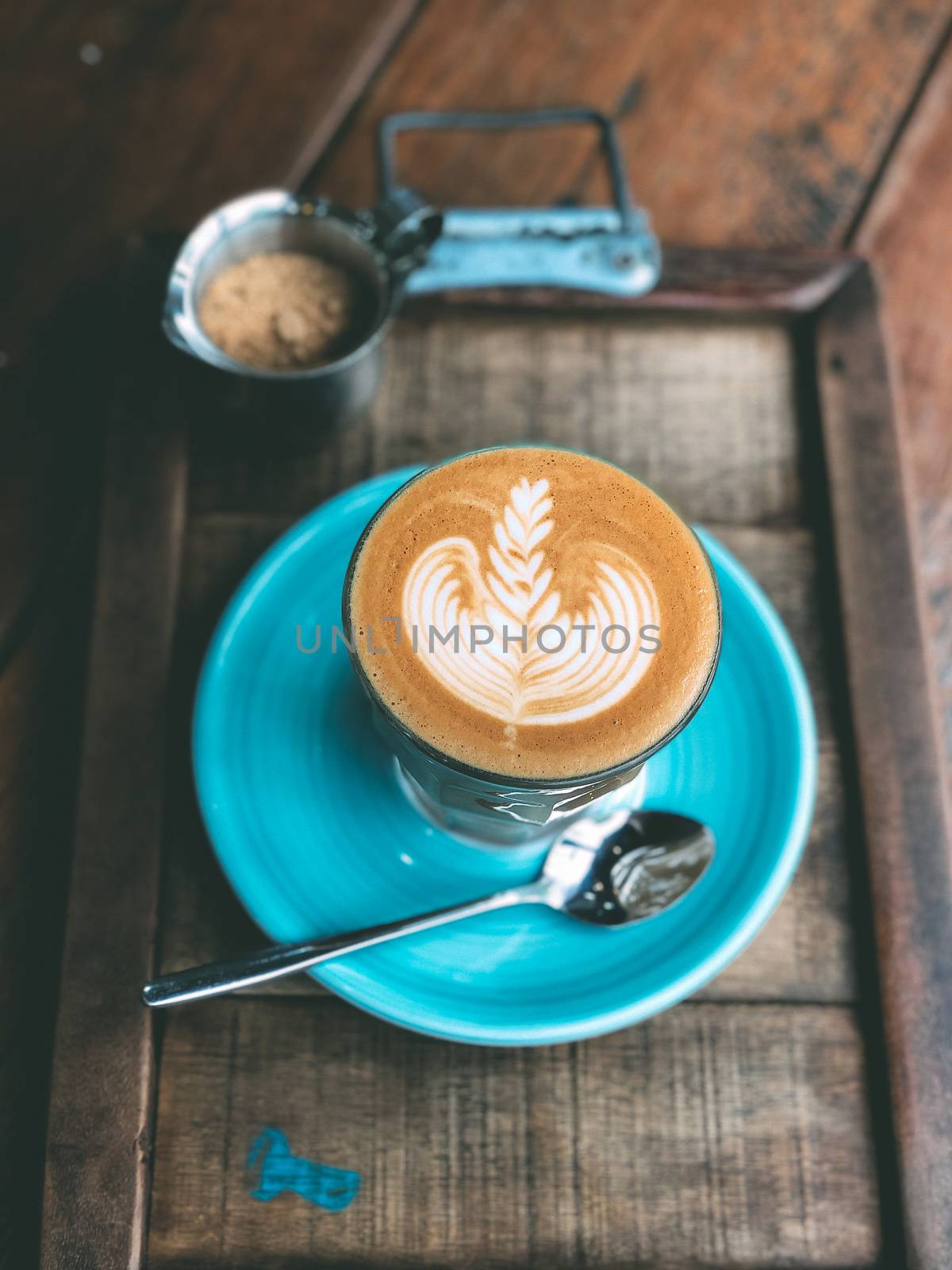 Cup of hot latte art coffee on vintage wooden table. by Benzoix