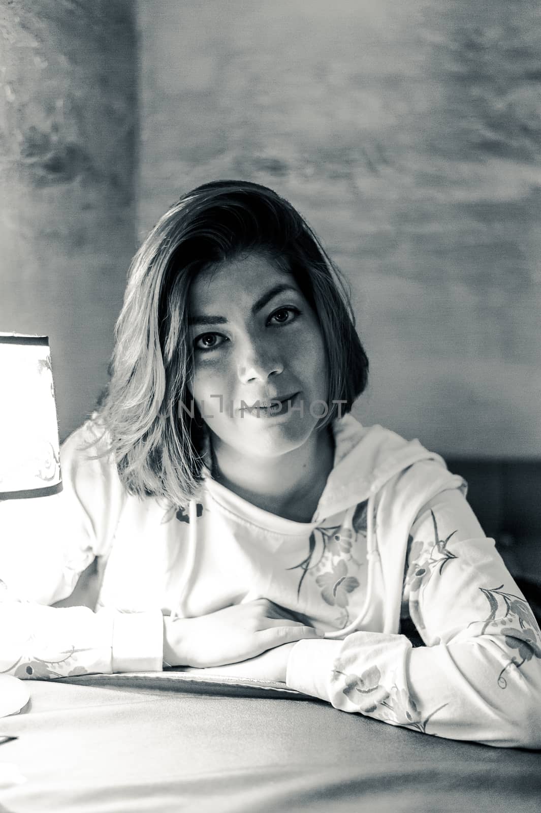 bw portrait of a smiling girl with very dark hair at a table in a cafe