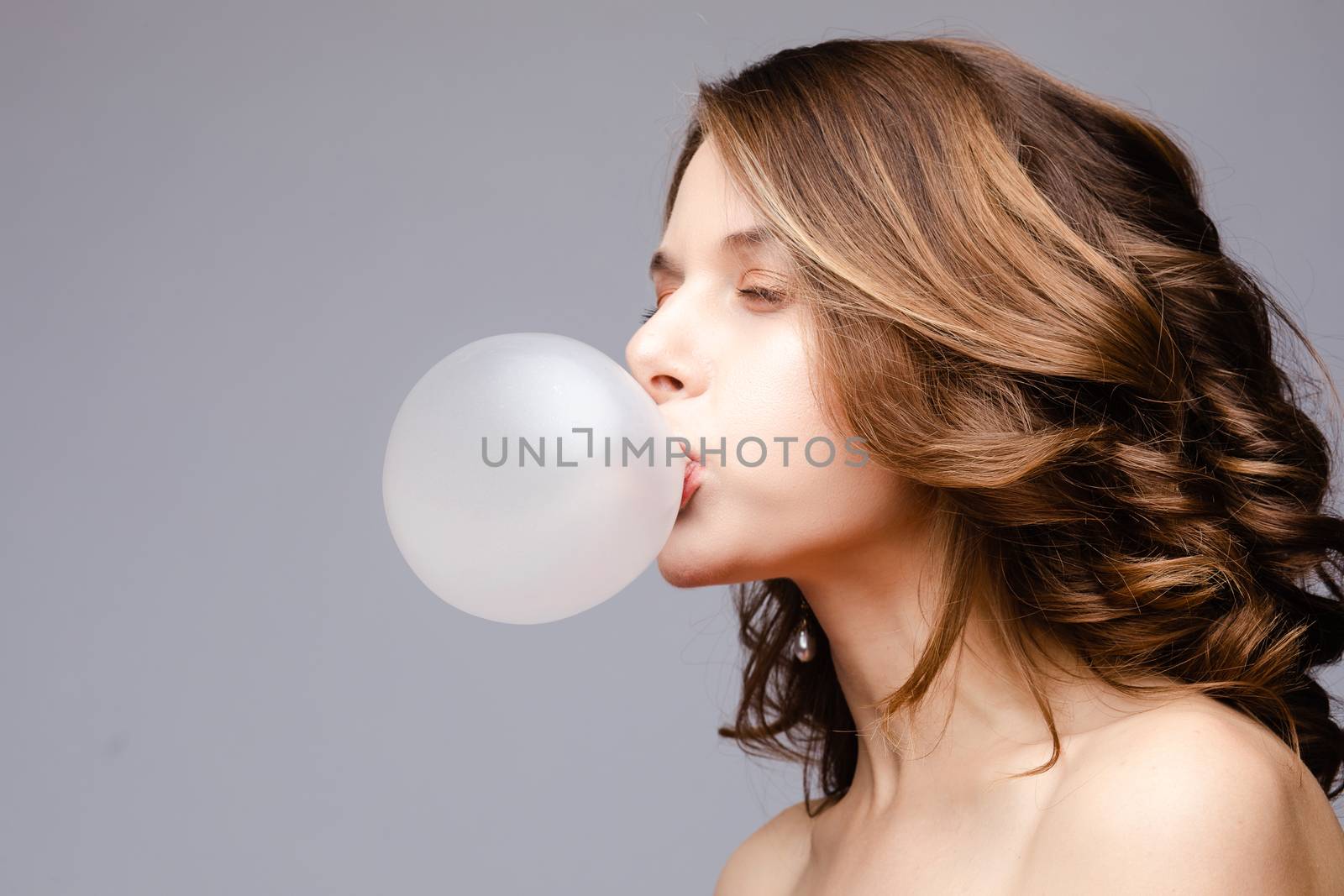 Charming young girl blowing bubble from chewing gum
