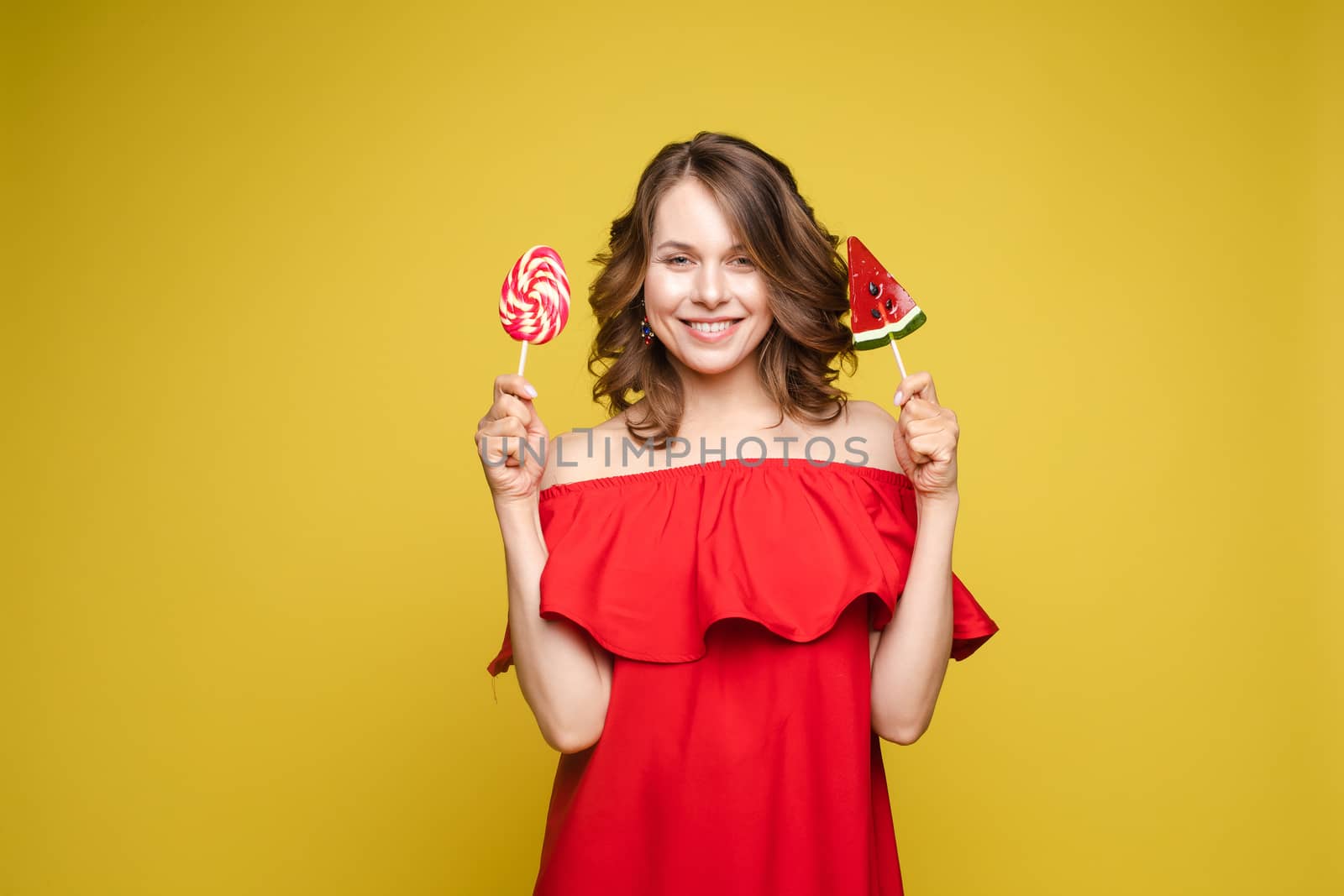 Fashionable young woman with lolipop in her hands on background by StudioLucky