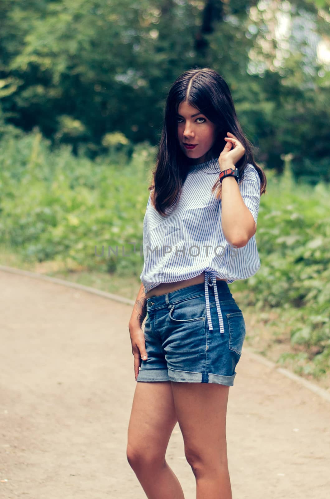 Outdoor portrait of young pretty beautiful calm woman posing outdoors in park