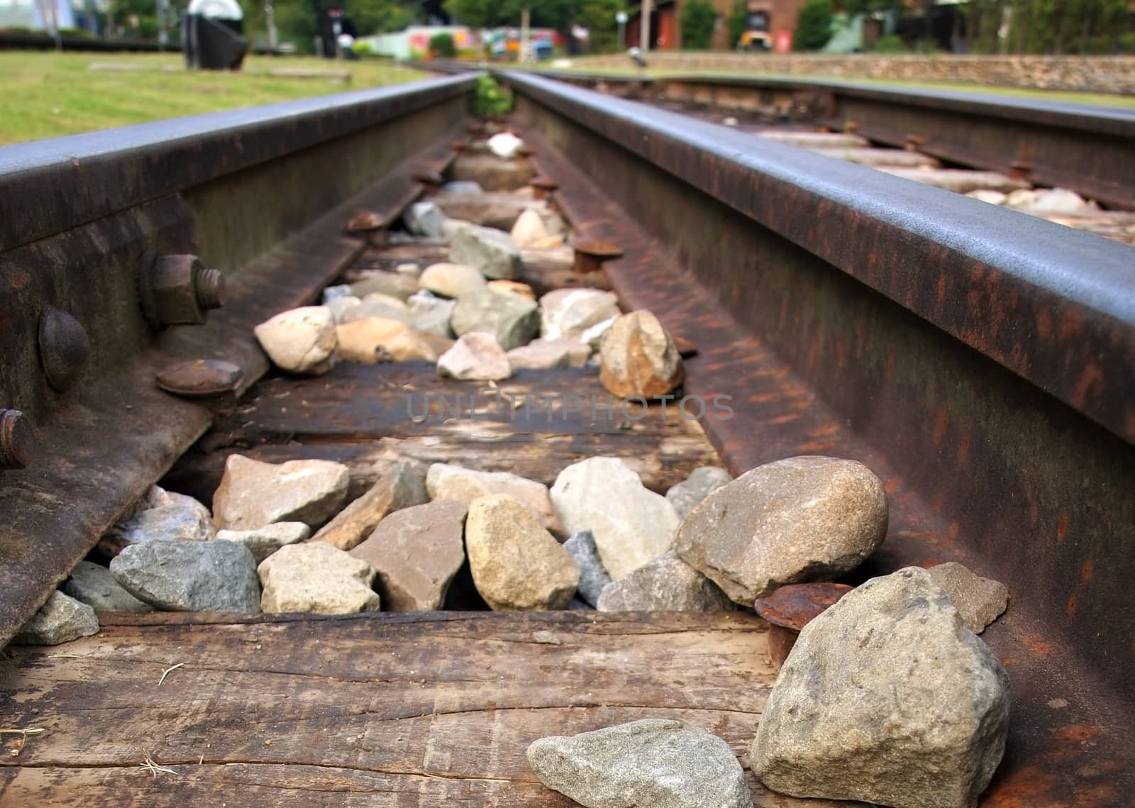 Two rusty steel railroad tracks are converging at a junction
